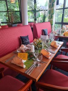 a wooden table in a restaurant with red chairs at Grandhotel Esplanade in Bad Nenndorf