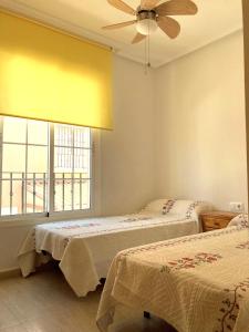 Un dormitorio con dos camas y un ventilador de techo. en Dúplex Bahía Terreros, en San Juan de los Terreros