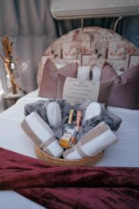 a basket of towels and cosmetics on a bed at The Franschhoek Stargazing Dome in Franschhoek
