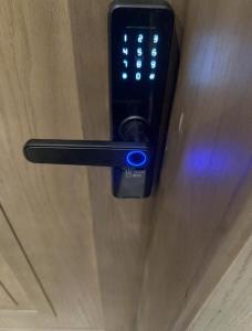 a remote control on a door with a blue light at Family Furnished Apartment in Khobar in Al Khobar