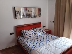 um quarto com uma cama e uma fotografia na parede em Miradore golfe em Martil