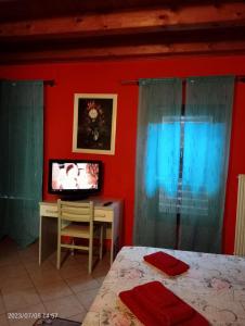 um quarto com uma cama, uma secretária e uma televisão em Da Marcela em Marostica