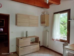 uma cozinha com armários de madeira, uma janela e uma cómoda em Da Marcela em Marostica