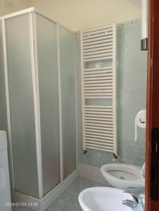 uma casa de banho com um chuveiro, um lavatório e um WC. em Da Marcela em Marostica