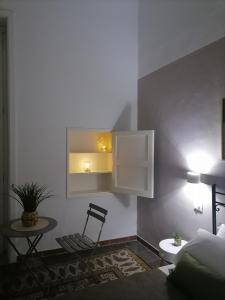 a room with a bed and a chair and a cabinet at AREMU in Lecce
