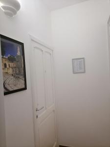 a room with a white door and a picture on the wall at AREMU in Lecce