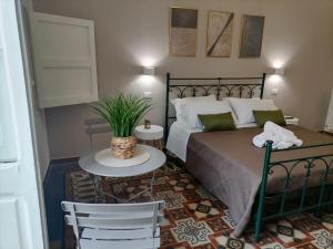 a bedroom with a bed and a table and chairs at AREMU in Lecce
