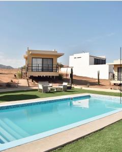 a swimming pool in front of a house at Sol del Valle in Valle de Guadalupe