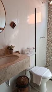 a white bathroom with a sink and a toilet at Pousada Estrelícia in Cunha