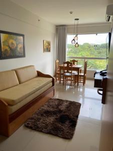 a living room with a couch and a dining room at PARK VEREDAS Flat 707 in Rio Quente