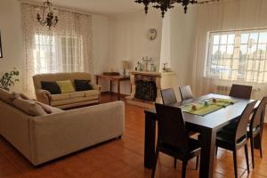 a living room with a table and a couch at Quinta Marinhais para férias no Ribatejo in Marinhais