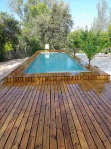 eine Holzterrasse mit einem Pool auf einem Haus in der Unterkunft Centro de Agroecologia y Medio Ambiente de Murcia in Bullas