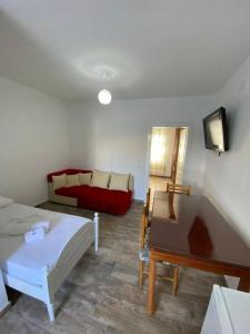 een woonkamer met een bed en een bank bij Arlind's Apartaments in Vlorë