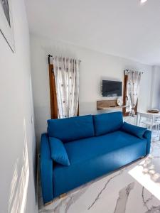 eine blaue Couch im Wohnzimmer in der Unterkunft MIRA LUXURY APARTMENTS in Paralia Dionisiou