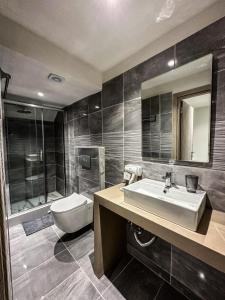een badkamer met een wastafel en een toilet bij MIRA LUXURY APARTMENTS in Paralia Dionysiou