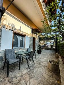 a patio with a table and chairs on a stone patio at MIRA LUXURY APARTMENTS in Paralia Dionysiou