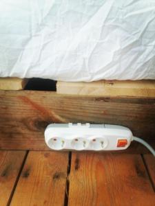 a white remote control sitting on the floor next to a bed at Stone Rose Glamping & Apartments in Tivat