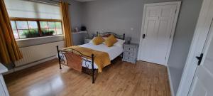 1 dormitorio con cama y ventana en The Madden Guest House, en Gilford