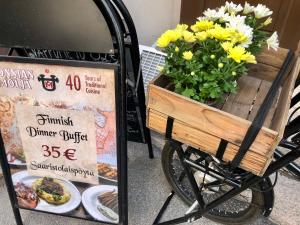 a wooden cart with flowers on it next to a sign at Scandinavian Desing Home 37 City Center in Kamppi in Helsinki