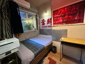 Habitación pequeña con cama y escritorio. en Wontonmeen en Hong Kong