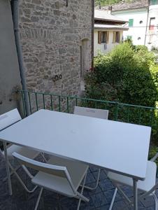 un tavolo bianco e sedie su un patio di Appartamento nel centro storico di Fiumalbo a Fiumalbo