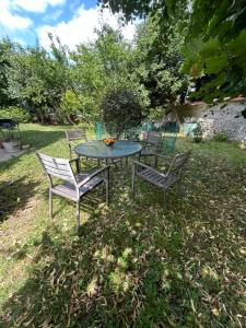 einen Tisch und Stühle im Gras in der Unterkunft Independent studio with garden in a charming guest house very close to Paris - separate entrance in Saint-Maur-des-Fossés