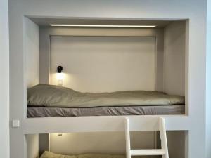 um quarto com uma cama num quarto branco em Hotellos em Copenhague