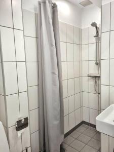 uma casa de banho com uma cortina de chuveiro e um lavatório em Hotellos em Copenhague