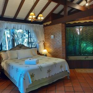 a bedroom with a bed in a room with a window at Urikana Boutique Hotel in Teresópolis