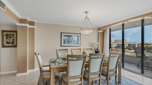 a dining room with a table and chairs and a balcony at 6415 Midnight Pass #611 in Siesta Key