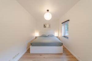 a bedroom with a bed in a white room at Coo'sy, proche de la cascade de Coo in Stavelot