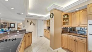 una cocina con armarios de madera y un reloj en la pared en 6415 Midnight Pass #611, en Siesta Key