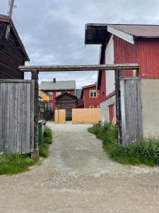 un antiguo granero con dos puertas de madera en un patio en Kjerkgata 6 - midt i Røros sentrum, en Røros