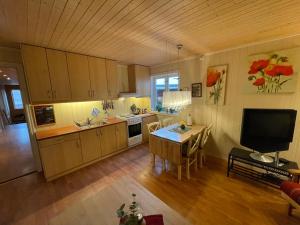 a large kitchen with a table and a television at Kjerkgata 6 - midt i Røros sentrum in Røros