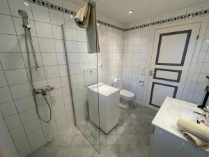 y baño con aseo, ducha y lavamanos. en Kjerkgata 6 - midt i Røros sentrum, en Røros