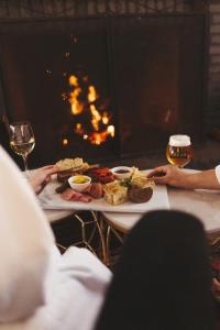 a table with a plate of food and a glass of beer at Mysa Nordic Spa & Resort in Saint Peters