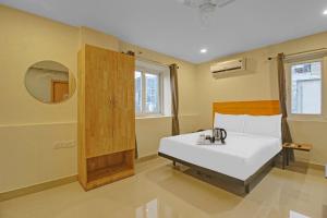 1 dormitorio con cama blanca y espejo en Super Townhouse 733 Whiteridge Gachibowli Near AIG Hospital en Hyderabad