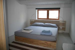 マリーナ・ディ・ラグーザにあるCasa del Sole fronte spiaggiaの窓付きの小さな部屋のベッド1台分です。