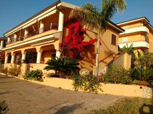 a building with red flowers in front of it at Villa Macria in Capo Vaticano