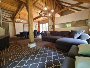 a living room with a blue couch and a rug at Landgoed De Lavei in Weleveld