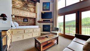 un soggiorno con letto, divano e camino di Timberline Condominiums Studio Loft Deluxe Unit 317 a Snowmass Village
