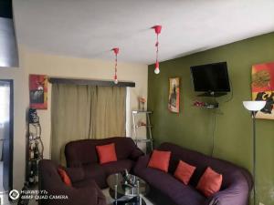 a living room with a couch and a tv at Casa Noria in Tepic