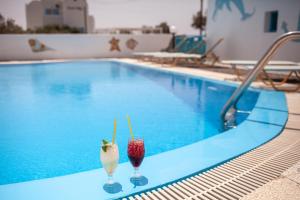 two milkshakes sitting on a table next to a swimming pool at Stella's place, Vlichada in Vlychada
