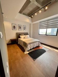 1 dormitorio con cama y ventana grande en Departamento Polanco Agora 10 en San Luis Potosí
