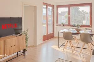 sala de estar con TV, mesa y sillas en City-Apartment Straubing, en Straubing
