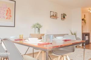 a dining room with a wooden table and white chairs at City-Apartment Straubing in Straubing