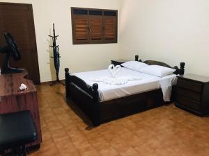 a bedroom with a bed with white sheets and a cross on it at Casa Morada das Flores in Areia