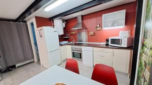 La Vaguada loft في مدريد: مطبخ مع ثلاجة بيضاء وجدران حمراء