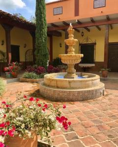La Unión的住宿－Casa Colonial San Alejo，花团锦簇的庭院中央的喷泉