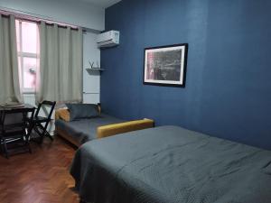 a room with two beds and a blue wall at Residencial Praia do Flamengo - Zona Sul Rio de Janeiro in Rio de Janeiro